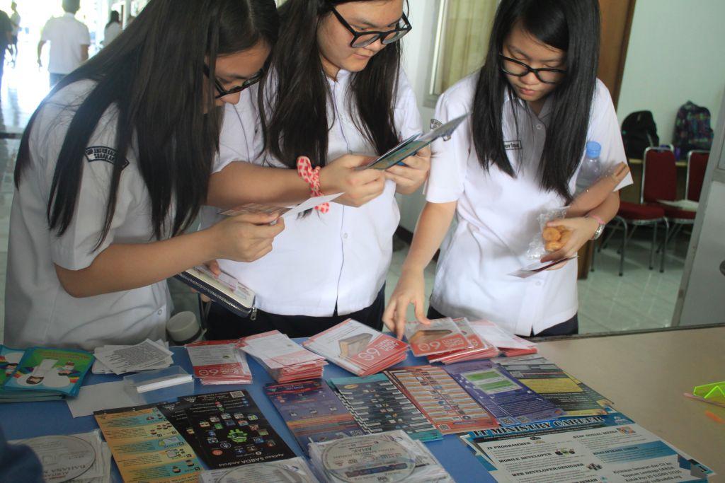 Siswi SMA Kalam Kudus mendatangi booth SABDA dan melihat brosur-brosur.